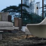 ANGIE armchair by GAMFRATESI STUDIO, designed in 2019. A saddle hide element designs a wing that embraces the armchair, sustaining the frame like a sculptural bustier characterized inside by the inviting softness. Behind the apparent simplicity of the design lies an advanced technological process used to make both the padding with different textures of foam and the saddle hide bustier, made using two different BAYDUR¬Æ moulds, which perfectly follows the curved line of the armchair and available in bordeaux, ash, dove grey, sage, mud, mocha and black colours.