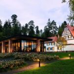 THE VILLA REN√â LALIQUE, 18 RUE BELLEVUE, 67290 WINGEN-SUR-MODER, FRANCE. The Villa, built by REN√â LALIQUE in 1920, represents the creative genius perfectly. Today it offers six exclusive suites and a refined restaurant that were designed by LADY TINA GREEN and PIETRO MINGARELLI and evoke the genius of REN√â LALIQUE down to the smallest detail. Each Art Deco inspired suite is different and bears the name of an iconic design. Every bed frame, sideboard, bedside table, sofa and mirror is decorated with crystal, showcasing LALIQUE‚Äôs expertise! The villa‚Äôs transformation has fully preserved the Alsatian house‚Äôs unique character. And a glass and steel annex, designed by Swiss architect MARIO BOTTA, has been built next to the villa, housing the restaurant. It uses columns made of characteristic Vosges red sandstone to support the green roof. The restaurant is adorned with LALIQUE's glass and crystal creations.