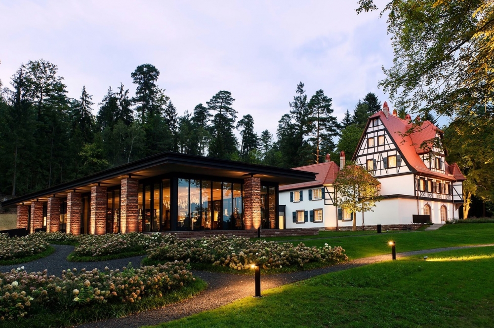 THE VILLA REN√â LALIQUE, 18 RUE BELLEVUE, 67290 WINGEN-SUR-MODER, FRANCE. The Villa, built by REN√â LALIQUE in 1920, represents the creative genius perfectly. Today it offers six exclusive suites and a refined restaurant that were designed by LADY TINA GREEN and PIETRO MINGARELLI and evoke the genius of REN√â LALIQUE down to the smallest detail. Each Art Deco inspired suite is different and bears the name of an iconic design. Every bed frame, sideboard, bedside table, sofa and mirror is decorated with crystal, showcasing LALIQUE‚Äôs expertise! The villa‚Äôs transformation has fully preserved the Alsatian house‚Äôs unique character. And a glass and steel annex, designed by Swiss architect MARIO BOTTA, has been built next to the villa, housing the restaurant. It uses columns made of characteristic Vosges red sandstone to support the green roof. The restaurant is adorned with LALIQUE's glass and crystal creations.