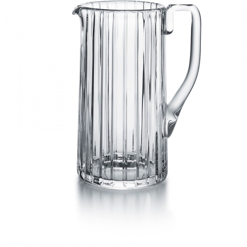 Baccarat HARMONIE pitche. Parallel vertical lines travel cleanly along the silhouette finely grazing the clear crystal form from the lip to the base. This linear emphasis evokes a thick clear crystal column.The stripes are subtly yet precisely etched into the clear crystal surface, showcasing the three-dimensionality of the pitcher and creating a visual depth to the liquid within. The vertical sweep of the striping is present throughout the HARMONIE collection, which includes highballs and tumblers and other pieces to complete a well-stocked bar. The HARMONIE pitcher is a stunning item that makes having a drink all the more enjoyable.
