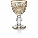 The HARCOURT EMPIRE glass revisits the HARCOURT‚Äôs regal architectural form. The HARCOURT collection, created in 1841, is the oldest in the Baccarat archive.Reputed for its iconic design, HARCOURT stemware has been used by historical icons throughout the ages. The HARCOURT EMPIRE glass shares the same structural outline as the HARCOURT glass, but adorned with exquisite golden embellishment. The flat cut pattern of the bowl has golden decorative shapes applied with a light hand, and a gilded rim. The geometric beveled stem remains classical, while the hexagonal foot is gold-trimmed around its perimeter. The glass sparkles both with lucid crystal and graceful gold. The HARCOURT EMPIRE collection also includes a champagne flute and highball. Baccarat‚Äôs Rivoli stemware collection has gilded features as well.