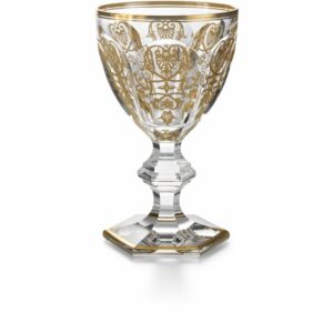 The HARCOURT EMPIRE glass revisits the HARCOURT‚Äôs regal architectural form. The HARCOURT collection, created in 1841, is the oldest in the Baccarat archive.Reputed for its iconic design, HARCOURT stemware has been used by historical icons throughout the ages. The HARCOURT EMPIRE glass shares the same structural outline as the HARCOURT glass, but adorned with exquisite golden embellishment. The flat cut pattern of the bowl has golden decorative shapes applied with a light hand, and a gilded rim. The geometric beveled stem remains classical, while the hexagonal foot is gold-trimmed around its perimeter. The glass sparkles both with lucid crystal and graceful gold. The HARCOURT EMPIRE collection also includes a champagne flute and highball. Baccarat‚Äôs Rivoli stemware collection has gilded features as well.