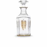HARCOURT EMPIRE whiskey decanter. With its golden details delicately applied to the crystal, the HARCOURT EMPIRE bottle will delight whiskey lovers, for an elegant tasting. HARCOURT was created in 1841 and is the oldest service in the Baccarat catalogue. Gold motifs have been applied to each flat cut by hand, and a gold trim delicately decorates one side. The bevelled, diamond cut stopper adds a touch of geometric sophistication to this classic shape. The HARCOURT EMPIRE collection is a perfect illustration of gleaming, luminous crystal decorated with gold detail, and also includes a wine glass, a cocktail glass, a champagne flute and a wine decanter.