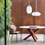 Table VAN DYCK whose sculptural design has made it an icon of Minotti style is now available in an outdoor version with an intriguing assortment of materials. The characteristic base made of welded metal tubes comes with a glossy painted finish in the following colours: clay, sunflower, rust and khaki green. The round top with contoured edges is available both in pietra del cardoso stone and silver beola stone - designer RODOLFO DORDONI