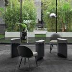 WEDGE DINING TABLE by NENDO, designed in 2019. Bulky look created by the solid sculptural masses of the semi-circular legs of wedge contrasts with the lightweight feet, which culminate in an oblique chisel tip shape. The entire volume of the table, hosting the large top, appears to become weightless and leans lightly on the tips of the legs, challenging the law of gravity.