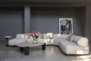 GOGAN SOFA BY PATRICIA URQUIOLA.THE DESIGN IS INSPIRED BY PEBBLES ON RIVERBANKS, WORN SMOOTH BY THE FLOW OF WATER AND OFTEN FEATURED IN JAPANESE ORNAMENTAL GARDENS. THE ORGANIC NATURE OF THE DESIGN IS EMPHASISED BY THE IRREGULAR SHAPE OF THE SEAT AND BACK, EXTRA SMOOTH EDGES AND CONCEALED SEAMS. THE BUTTRESS-LIKE FRAME, VISIBLE AT THE BACK OF THE SOFA, CREATES A SENSE OF LIGHTNESS BY LIFTING THE SEAT OFF THE FLOOR AND CREATING A GAP BETWEEN THE SEAT AND THE BACKREST. THE RESULT IS A BEAUTIFULLY SCULPTURAL SOFA WHICH FEELS MONUMENTAL AND LIGHT AT THE SAME TIME, PERFECT FOR USE IN BOTH RESIDENTIAL AND PUBLIC AREAS.