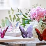 PAPILLON LUCKY BUTTERFLY. The poetic contours highlight Baccarat‚Äôs signature craftsmanship. Placed anywhere in the home, the Baccarat LUCKY BUTTERFLY elicits a sense of momentum and graceful √©lan. Designed for Baccarat by EVELYNE JULIENNE, this fascinating creature comes in a wide variety of available colors including: blue, peony, ruby red, amber, turquoise blue crystal, black, gold, blue scarabee and clear iridescent crystal (with tinges of green, yellow and blue).