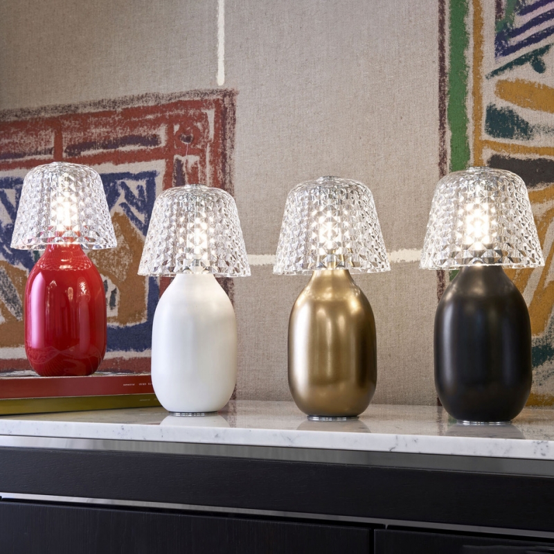 BABY CANDY LIGHT nomadic lamp. BABY CANDY LIGHT becomes now nomadic in 4 iconic colors: glossy Baccarat red, matte bronze, matte white and matte black. Wireless, this nomadic lamp is an elegant and playful solution to light up and decorate indoor tables as well as terrace tables. Rechargeable, its ceramic body is topped with a crystal shade inspired by the Juvisy-cut motif. A button on the top of the lampshade enables to dim the light by a gentle and continuous touch.