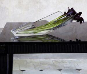 DIVA vase. Its unexpected and avant-garde silhouette reinvents expectations of design and reconfigures the possibilities for creating a compelling floral arrangement. The open cylinder of clear crystal cradles the floral assembly and keeps it carefully in place, yet still gives the plants plenty of room to breathe. Moreover, this vase makes it possible to place a bouquet on the table and still be able to see the person sitting on the opposite side. It is both a conversation piece and a work of impeccable craftsmanship.  / available in 2 sizes