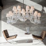 Crystal chandelier 16 lights ELLIPSE - designer ARIK L√àVY. Inspired by cold-worked crystal, the chandelier references the magical malleability of the crystal form. The Z√âNITH ELLIPSE shakes up the traditional assembly principles, notably with its slightly staggered branches that evolve from round to oval through anamorphosis. A feat of outstanding craftsmanship, the Clear crystal chandelier can be adjusted to any height. The 16-lights may be adorned with white pleated taffeta lampshades (must be ordered separately).