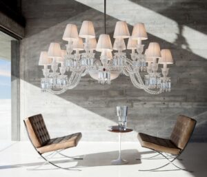 Crystal chandelier 16 lights ELLIPSE - designer ARIK L√àVY. Inspired by cold-worked crystal, the chandelier references the magical malleability of the crystal form. The Z√âNITH ELLIPSE shakes up the traditional assembly principles, notably with its slightly staggered branches that evolve from round to oval through anamorphosis. A feat of outstanding craftsmanship, the Clear crystal chandelier can be adjusted to any height. The 16-lights may be adorned with white pleated taffeta lampshades (must be ordered separately).