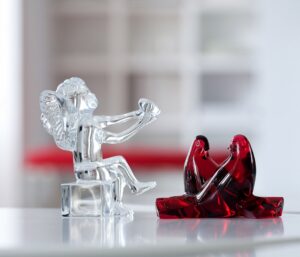 ANGE CHERUB designed by JEAN-PIERRE GODON. Gracefully seated with criss-crossed legs and extended arms, this wholesome cherub willingly offers his heart to the person he adores. The cherub‚Äôs face is titled upwards, cementing the connection between himself and his loved one with this declarative gesture. Designed by JEAN-PIERRE GODON for Baccarat, this little cupid is a wonderfully tender-hearted emblem of devotion. Be it to celebrate Valentine‚Äôs Day or honor an anniversary, this angel figurine is suitable for any sentimental occasion that warrants a beautiful token of affection for your beloved.