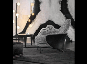 ANGIE armchair by GAMFRATESI STUDIO, designed in 2019. The GAMFRATESI STUDIO, signing the design, worked on the idea of contrast, emphasising it and juxtaposing the stiff frame of the saddle hide element with the softness of the upholstered part, which can also be seen on the back, so setting the scene for interesting colour combinations of saddle hide and fabric. The legs are in pewter-coloured die-cast aluminium and a unique bow-shaped frame connects the feet at the rear, emphasising the curve of the saddle hide body.