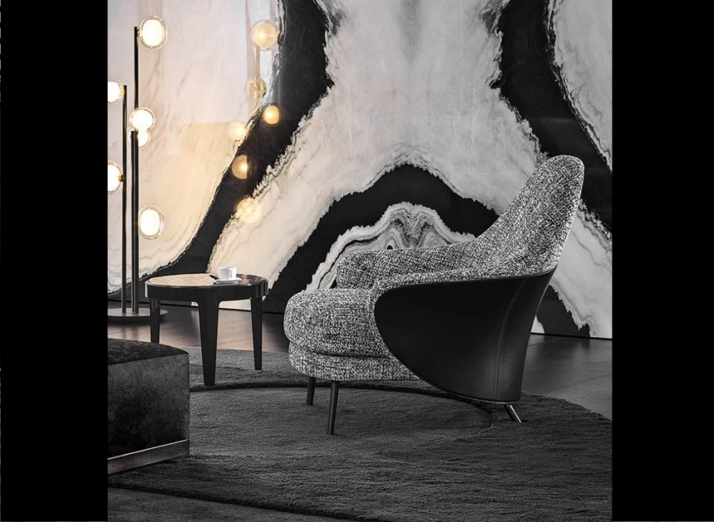 ANGIE armchair by GAMFRATESI STUDIO, designed in 2019. The GAMFRATESI STUDIO, signing the design, worked on the idea of contrast, emphasising it and juxtaposing the stiff frame of the saddle hide element with the softness of the upholstered part, which can also be seen on the back, so setting the scene for interesting colour combinations of saddle hide and fabric. The legs are in pewter-coloured die-cast aluminium and a unique bow-shaped frame connects the feet at the rear, emphasising the curve of the saddle hide body.