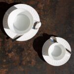 Porcelain tableware TWIST. The delicate design of this new collection combines various influences: the light effects of the rice paper Japanese screens, the art of origami folding, the braiding and caning of the furniture of the 50s, not to mention the 3D graphics offered by the new technologies. The result is an unprecedent subtle effect of a rigorously geometric pattern taken in twisted momentum. Engraved on the rim of the plates and on the outside of the various pieces of the collection, it is the light that reveals the alternation of matt and shining rendering giving a vibrant radiance that enlivens the whiteness of porcelain.