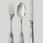 MOLI√àRE MASCARON cutlery collection. This Regency-style (1690-1730) sterling silver model is distinguished by the elegance of its form and its refined naturalistic decor. Acanthus flowers and stylized ribbons dramatically intertwine to embellish the handles of the cutlery. The tips of the fork and knife are molded with a theatrical mask face and the spoon features a vegetal mascaron.