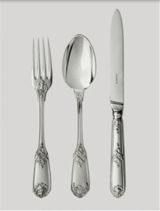 MOLI√àRE MASCARON cutlery collection. This Regency-style (1690-1730) sterling silver model is distinguished by the elegance of its form and its refined naturalistic decor. Acanthus flowers and stylized ribbons dramatically intertwine to embellish the handles of the cutlery. The tips of the fork and knife are molded with a theatrical mask face and the spoon features a vegetal mascaron.