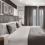 LALIQUE SUITE by PATRICK HELLMANN at HOTEL PRINCE DE GALLES, PARIS. DESIGNER PATRICK HELLMANN has swathed the entire suite in a mosaic of mostly black and gold to bring that Art Deco look to life, and then layered it with texture, such as sculptural side tables and blonde wood furniture, to provide some balance. HELLMANN also selected some iconic crystal pieces for the renovation, like the SEVILLE CHANDELIER‚Äîfirst designed by MARC LALIQUE in 1947‚Äîthat hangs over the curvy black-and-gold staircase that leads up to the bedroom.