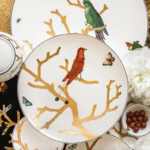 AUX OISEAUX collection. Inspired by the curiosity cabinets that were so fashionable in the 16th and 17th centuries, the pattern is available on a full dinnerware service with scenes reminiscent of japanese prints: birds depicted in automnal colors perch on stylised trees in raised gold.