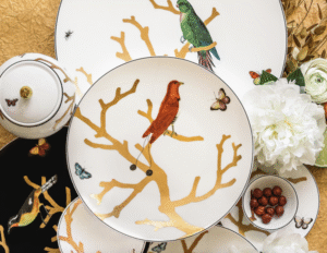 AUX OISEAUX collection. Inspired by the curiosity cabinets that were so fashionable in the 16th and 17th centuries, the pattern is available on a full dinnerware service with scenes reminiscent of japanese prints: birds depicted in automnal colors perch on stylised trees in raised gold.