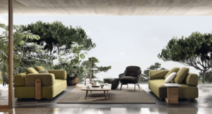 FLORIDA outdoor seating system by RODOLFO DORDONI, designed 2022.Natural teak is the wood chosen for FLORIDA to complement the mood of the 2020 Collection and design living compositions blurring the boundaries between indoors and outdoors.  The FLORIDA coffee table features feet in solid natural teak wood and a top with shaped edge in Pietra del Cardoso, in a brushed finish. Due to its mineral composition, Pietra del Cardoso is exceptionally compact and extremely weatherproof.