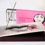 INCENSE BOX FIOR DI BACIO. THE SET INCLUDES 80 INCENSE STICKS AND A DARK WOODEN BOX TOPPED WITH A CERAMIC LID TO HOLD THE STICKS WHEN LIT