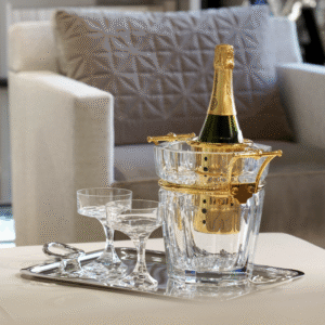 HARCOURT champagne cooler. A symbol of elegance, champagne adorns itself in the most beautiful setting possible. The Harcourt champagne bucket enhances the clear crystal's purity with silver or gold-plated handles, making it a luxurious table element. NARCISSE champagne coupes perfectly complete the scene. NARCISSE COUPE by BORIS TABACOFF IMAGINED the NARCISSE set back in 1971. In gift-set of two champagne coupes, the NARCISSE glasses add a sublime touch to the most original dinner table with its timeless design.