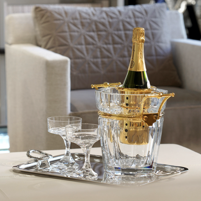 HARCOURT champagne cooler. A symbol of elegance, champagne adorns itself in the most beautiful setting possible. The Harcourt champagne bucket enhances the clear crystal's purity with silver or gold-plated handles, making it a luxurious table element. NARCISSE champagne coupes perfectly complete the scene. NARCISSE COUPE by BORIS TABACOFF IMAGINED the NARCISSE set back in 1971. In gift-set of two champagne coupes, the NARCISSE glasses add a sublime touch to the most original dinner table with its timeless design.