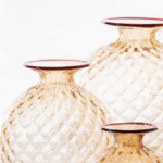 MONOFIORE BALLOTON vase, designed by VENINI,1970. It looks soft, but it's glass. The optical illusion is couched in its name: Balloton, the traditional glassblowing technique that recreates the matelass√© look on the surface. A fine lip in a contrasting colour hot-worked around the mouth of the vase shows the glassworks‚Äô signature style.Small vials, like ancient treasures that have been discovered in unknown places. Perhaps in the room of a refined woman from the past, a lover of beauty and fragrance. These blown glass ampoules with caps have the delicacy of personal belongings, with details that appear like curious florets blooming upward.