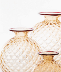 MONOFIORE BALLOTON vase, designed by VENINI,1970. It looks soft, but it's glass. The optical illusion is couched in its name: Balloton, the traditional glassblowing technique that recreates the matelass√© look on the surface. A fine lip in a contrasting colour hot-worked around the mouth of the vase shows the glassworks‚Äô signature style.Small vials, like ancient treasures that have been discovered in unknown places. Perhaps in the room of a refined woman from the past, a lover of beauty and fragrance. These blown glass ampoules with caps have the delicacy of personal belongings, with details that appear like curious florets blooming upward.