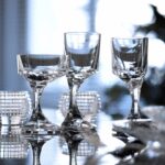 NARCISSE glass. A sculptor and furniture designer, BORIS TABACOFF imagined the NARCISSE set back in 1971. In gift-set of two glasses, the NARCISSE glasses add a sublime touch to the most original dinner table with its timeless design. An asymmetrical and distinctly avant-garde creation embracing the quest for new shapes. In the image of the narcissus, whose flowers bend and lean towards water, the off-center glass bowl seems to bow. The perfect balance is obtained thanks to the talent of the manufactory's artisans.