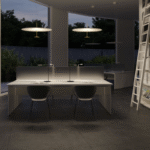 Pendant lamp DOT by FOSTER + PARTNERS.Dot is a family of pendant lamps designed by Foster + Partners to make luminaires look like disks of light. Their design neatly combines formal rigour and the most advanced lighting technology. Dot has two differently sized parallel disks connected through their centres by a thin metal tube. The bottom, smaller disk is turned aluminium and contains a LED ring optically engineered to cast a high quantity of light onto the top disk, the diffuser, made of lacquered aluminium.  The high-powered source generates an amount of heat that the bottom disk could not dissipate on its own. The problem was solved by placing a special heat sink (used in the aerospace industry) in the thin tube connecting the disks. Its function is to thermally connect the LED circuit to a heat dissipator housed in the top disk. On being switched on, the Dot is a thin, lightweight disk, seemingly suspended in mid-air, that generates an enveloping flux of light without shadows. Dot comes in three different diameters and power ratings: √∏60cm (23W), √∏80cm (41W), √∏110cm (55W). There are two finishes.