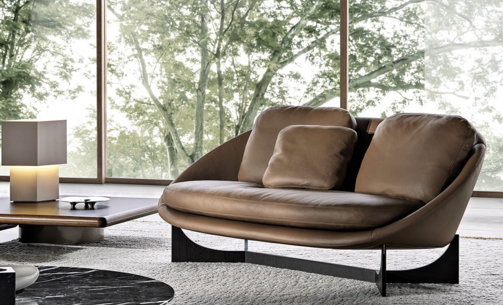 LIDO sofa by GAMFRATESI, designed 2022. The volume of the sofa is raised from the ground by four solid wood legs, in Moka-coloured open-pore polished ash or Canaletto walnut with a Dark Brown stained veneer. Alternatively, it can rest on the iconic X-shaped aluminium base with Moka-coloured open-pore polished ash finish, imbuing this object with timeless beauty and making it easy to pair with the other furnishing pieces in the collection. The base and legs are enhanced by an interesting decorative insert in Bronze-coloured varnished steel at the top of the legs.
