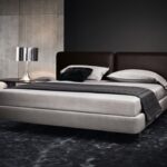 BED TATLIN IS ALL ABOUT THE HEADBOARD; UPHOLSTRED IN SADDLE -HIDE , IN THE COLOURS MUD; TOBACCO AND BLACK, WITH DETAILED WORKMANSHIP THAT CALLS TO MIND REFINED LUGGAGE - IN THE ROUNDED CORNELS ,THE STITCHING ,THE LUSH THICKNESS - DESIGNER RODOLFO DORDONI