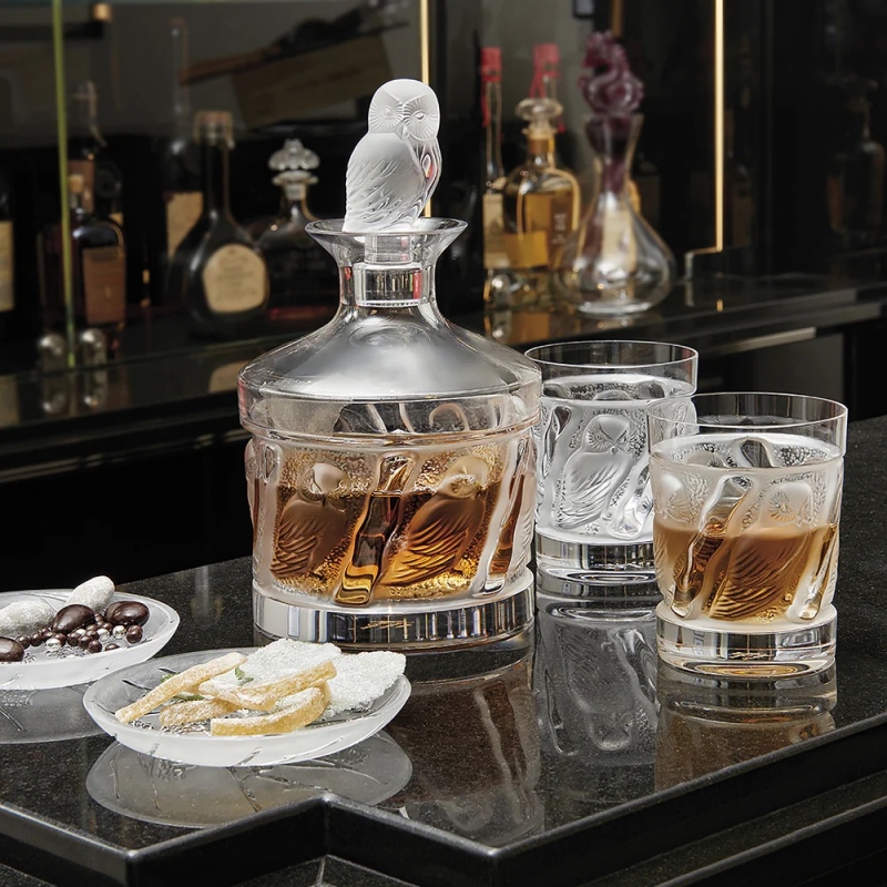OWL OLD FASHION tumbler. In 1994, the Owl, a mythical bird symbolising wisdom, inspired Lalique to create two tumblers featuring strong, structured lines. In 1995, a decanter is added to the range, with a very original shape and crystal owl stopper.
