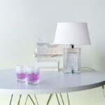 Clear crystal lamp based on an EYE vase with horizontal bevelled cuts outside and vertical ones inside making a kinetic diamond-cut effect. White fabric lampshade included, Structure in shiny chrome finish steel. Transparent electric wire (with a light dimmer for CEI verson).