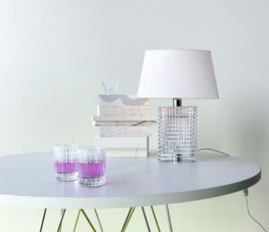 Clear crystal lamp based on an EYE vase with horizontal bevelled cuts outside and vertical ones inside making a kinetic diamond-cut effect. White fabric lampshade included, Structure in shiny chrome finish steel. Transparent electric wire (with a light dimmer for CEI verson).