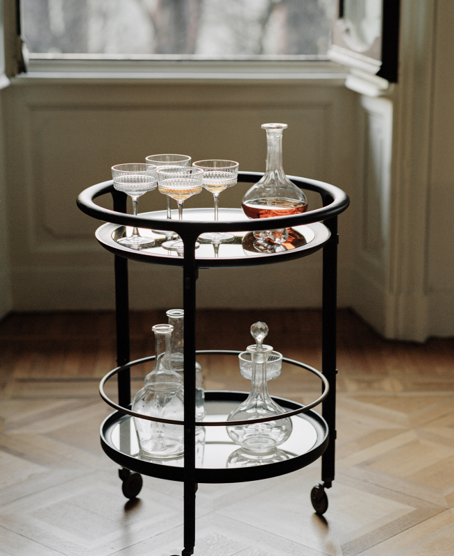 DUO bar trolley by ROBERTO LAZZERONI. DUO bar trolley is the wheeled bar cart with solid ash wood frame in various finishes. The upper glass top can be clear, bronzed or smoked; the lower top can be marble, back-painted glass or multilayer veneered ash in the same finish chosen for the frame. The bronzed brass details create a pleasing contrast with the solid wood frame.