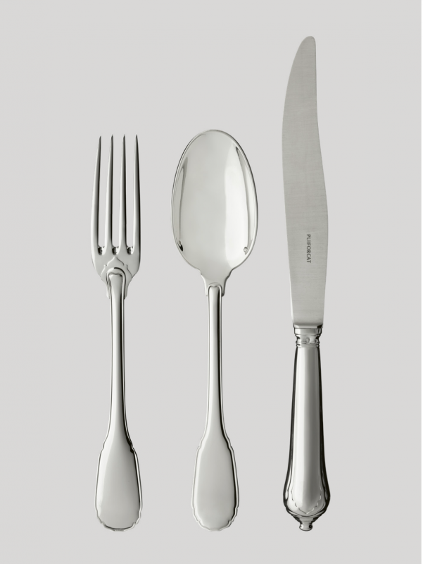 NOAILLES cutlery collection. Since the 16th century, Augsburg, Bavaria has been renowned for the unparalleled savoir-faire of its silversmiths. For Louis-Victor Puiforcat, a keen collector of high-quality pieces, an early design from this Bavarian city inspired the production of this sterling silver cutlery. The apparent simplicity of the design is contrasted by the refinement of every detail: the curved contour, the handle outlined with a fine thread, the elegant flame- shaped button at the base of the fork and spoon