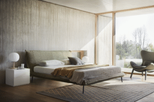 FLUFF bed designed by DANIELE  LO SCALZO MOSCHERI. Fluff stands apart for its sobriety and linear simplicity. We upholstered a well-proportioned lightweight frame and made it one with the headboard, forming a single body attached with invisible seams. The mattress seems suspended in air although it rests on a slight yet sturdy structure set on slender metal feet. The edges of the whole bed have been trimmed with a fabric band detail which accentuates the superior textile workmanship of the product.