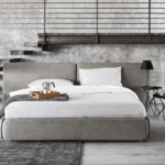 ZIP bed designed by DANIELE  LO SCALZO MOSCHERI. ZIP is a versatile, unisex and laid-back project whose sleek design hinges on a common household object - a zip. The ZIP is a decorative and functional feature for wrapping the padded panels and transforming simple accessories into a product which can be put together to suit your requirements. The upholstered bed has fully removable covers. This item is available with a plexiglass foot. The ZIP bed is available with a fixed bed frame and can be upholstered in fabric or leather with a matching beige, brown, light-grey or dark-grey zip.