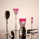 A new tumbler joins the legendary Tsar Service. Created in 1909 for Nicholas II, this iconic service is one of Baccarat’s most historic royal commissions. The Maison reimagines its spirit with a creation that blends heritage and boldness. Crafted in clear and red double-cases crystal, Baccarat’s signature color, achieved with the addition of 24-carat gold powder, the new tumbler features contemporary lines and bears the signature of artisanal excellence. Its diamond and palm leaf pattern is cut with extreme precision by a Meilleur Ouvrier de France. Each facet captures and reflects light with intensity, transforming the tumbler into a true work of sculptural art. A refined piece to enjoy both in life’s grand celebrations and its everyday moments—true to the Baccarat spirit: a symbol of unforgettable occasions and shared joy for over 260 years.