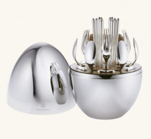 MOOD Party by Christofle. Designed for one's informal dining moments, MOOD Party by Christofle is a set featuring cutlery for 6 people for life's sweet & savory moments. The set includes the following: 6 butter knives, 6 small spoons, 6 appetizer/dessert forks, 6 silver-plated cocktail picks, 1 storage capsule. The egg-shaped storage capsule is made of a mirror-polished steel with a walnut base interior. Christofle shakes up the art of entertaining with a new concept that reflects the current zeitgeist. MOOD Party by Christofle, with its avant-garde vision of convenience and comfort, invites itself to all tables as a promise of sharing and memories.